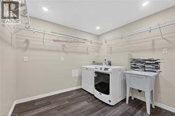 Laundry room featuring wood-finish flooring, recessed lighting, wire shelving, and a utility sink with a tiled backsplash -