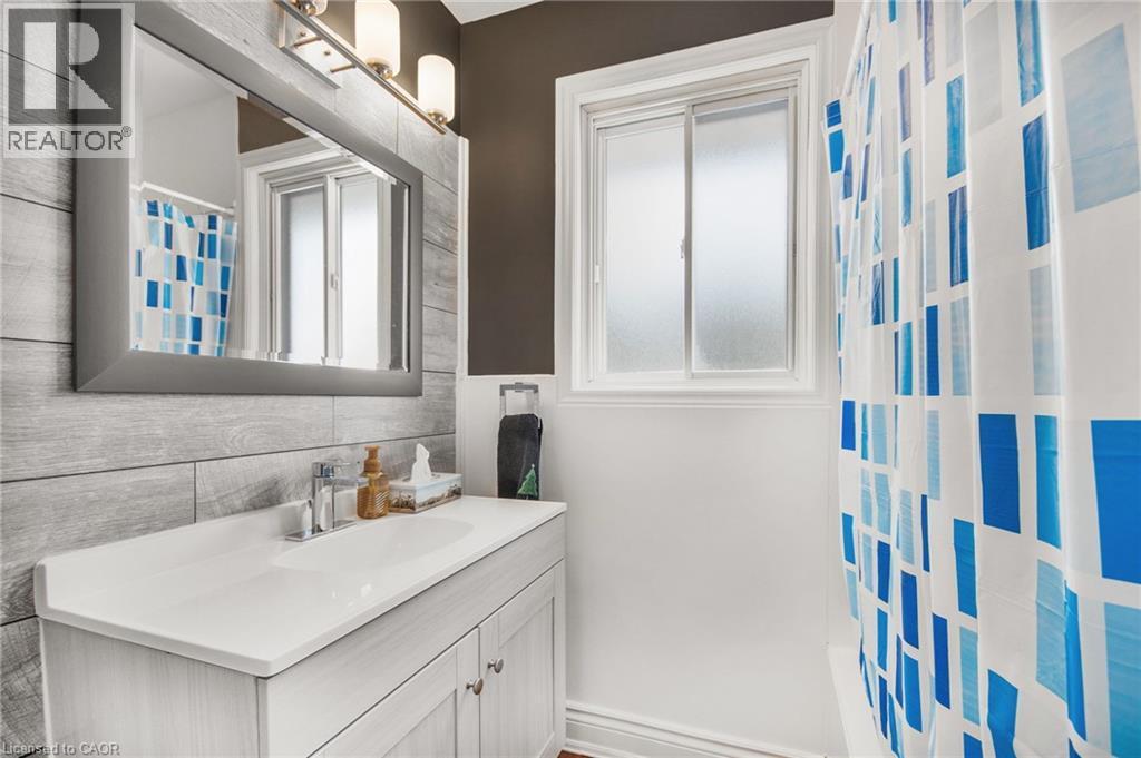 Vanity with integrated sink, chrome faucet, and storage cabinetry - 185 Burlington Street, London, ON - Indoor Photo Showing Bathroom