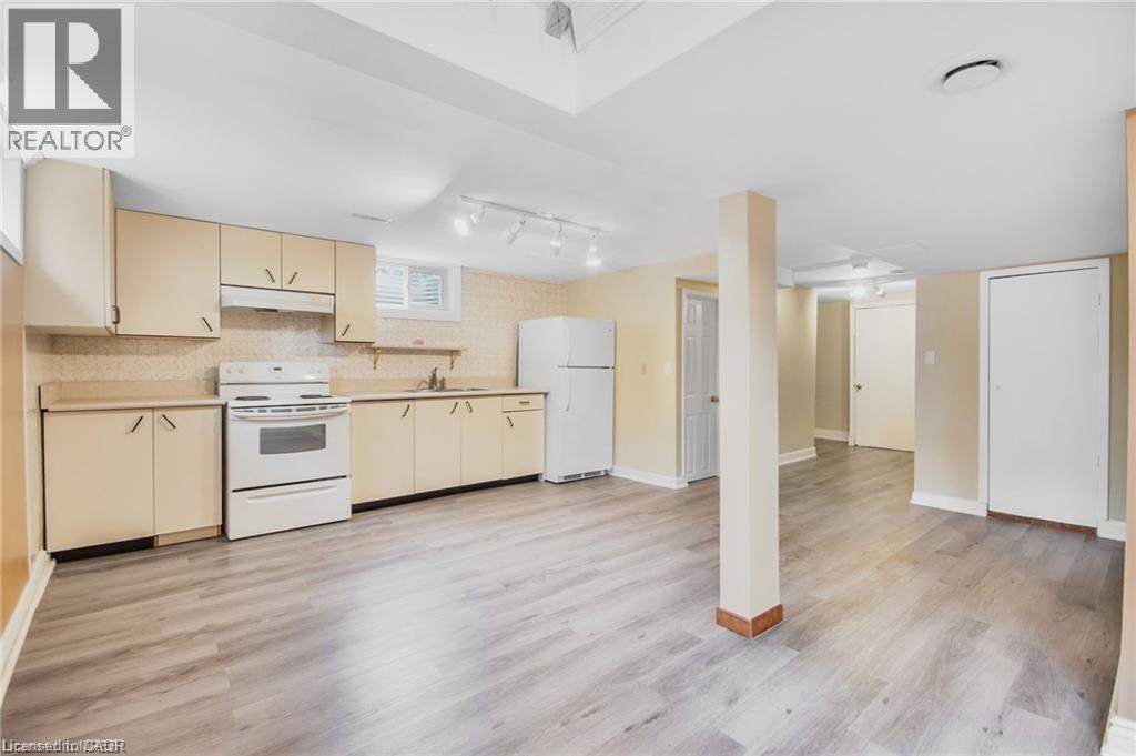 Kitchen area featuring wood-finish flooring, light-toned cabinetry, and white appliances - 185 Burlington Street, London, ON - Indoor Photo Showing Kitchen