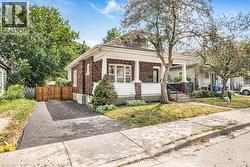 Brick exterior with white siding accents and a covered front porch featuring white columns - 