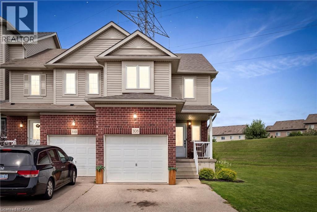 Brick and siding exterior featuring an attached garage, paved driveway, and mature landscaping - 308 Parkvale Drive, Kitchener, ON - Outdoor With Facade