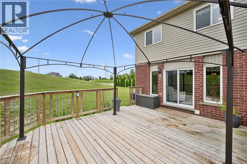 Expansive wooden deck with wooden railings, red brick exterior, siding upper level, and a sliding glass door - 308 Parkvale Drive, Kitchener, ON - Outdoor With Deck Patio Veranda With Exterior