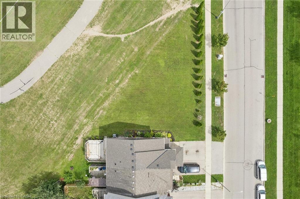 Gabled roofline, asphalt shingle roofing, paved driveway, concrete sidewalks, and a manicured lawn - 308 Parkvale Drive, Kitchener, ON - With View