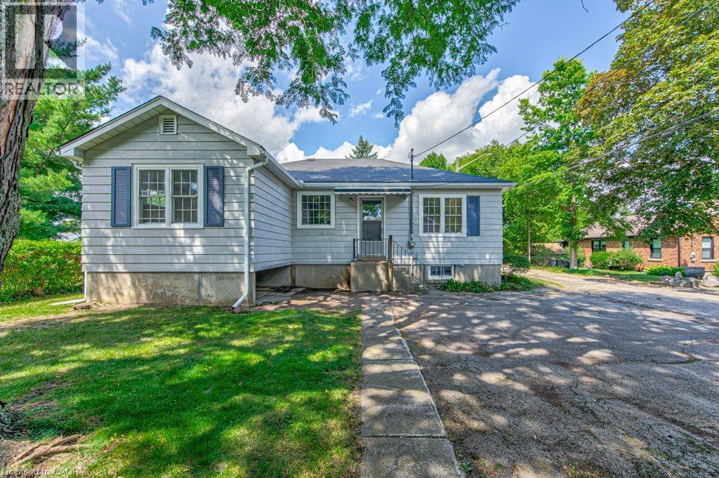 Single-story residence featuring light-colored siding, a dark roof, and blue decorative window shutters - 321 Highland Park, Cambridge, ON