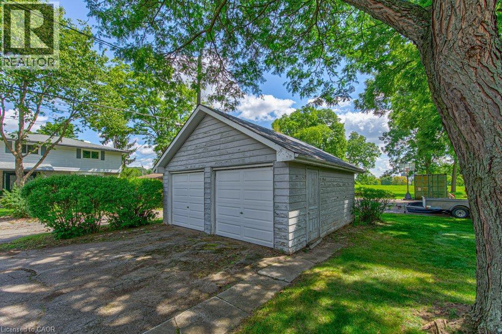 Detached two-car garage with shingle siding, asphalt driveway, and mature landscaping - 321 Highland Park, Cambridge, ON