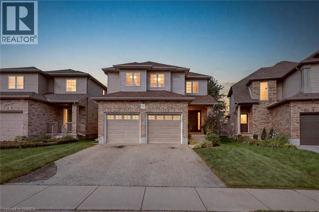 Two-story residence featuring a brick and siding exterior, a double garage, and a concrete driveway - 783 Frontenac Crescent, Woodstock, ON - Outdoor With Facade