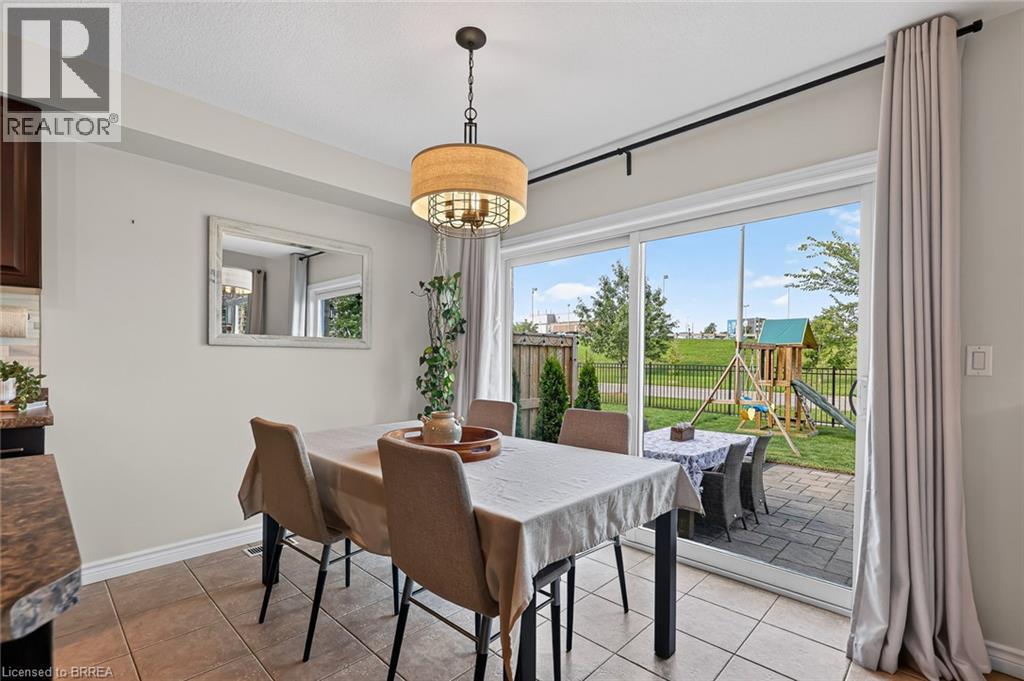Tiled flooring, overhead light fixture, sliding glass door, paved patio, and fenced backyard - 783 Frontenac Crescent, Woodstock, ON - Indoor Photo Showing Dining Room