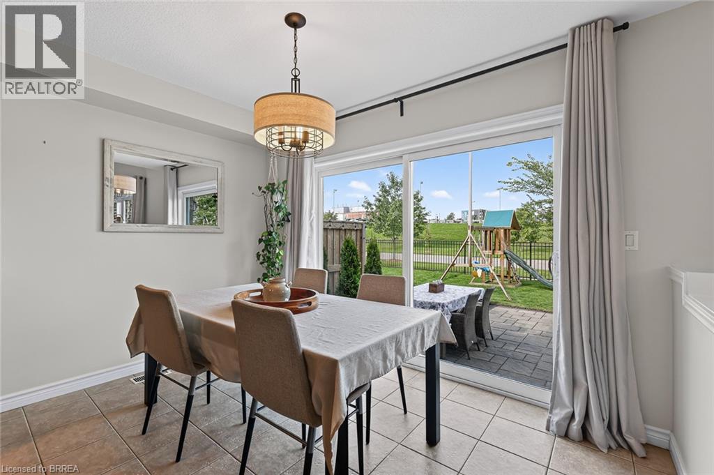 Dining area featuring a drum pendant light fixture, ceramic tile flooring, and a sliding glass door - 783 Frontenac Crescent, Woodstock, ON - Indoor Photo Showing Dining Room