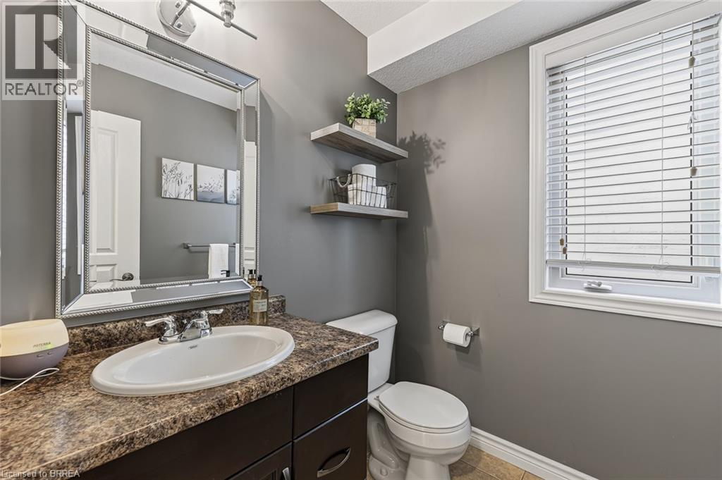 Bathroom with a single vanity, a polished chrome faucet, and a decorative framed mirror - 783 Frontenac Crescent, Woodstock, ON - Indoor Photo Showing Bathroom