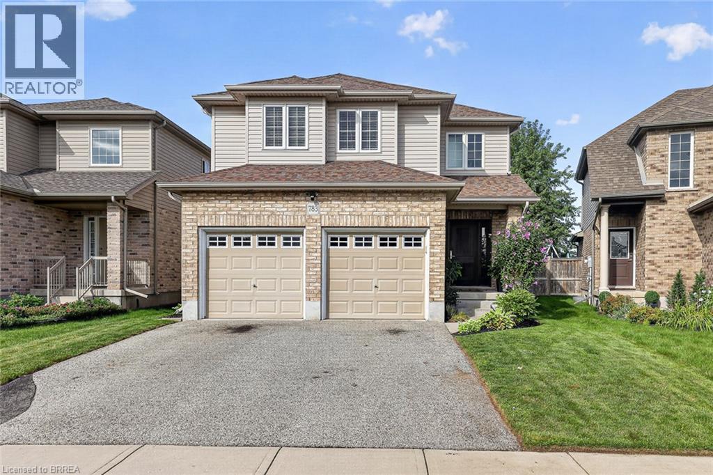 Stone and siding exterior with a two-car garage, front entry, and mature landscaping - 783 Frontenac Crescent, Woodstock, ON - Outdoor With Facade
