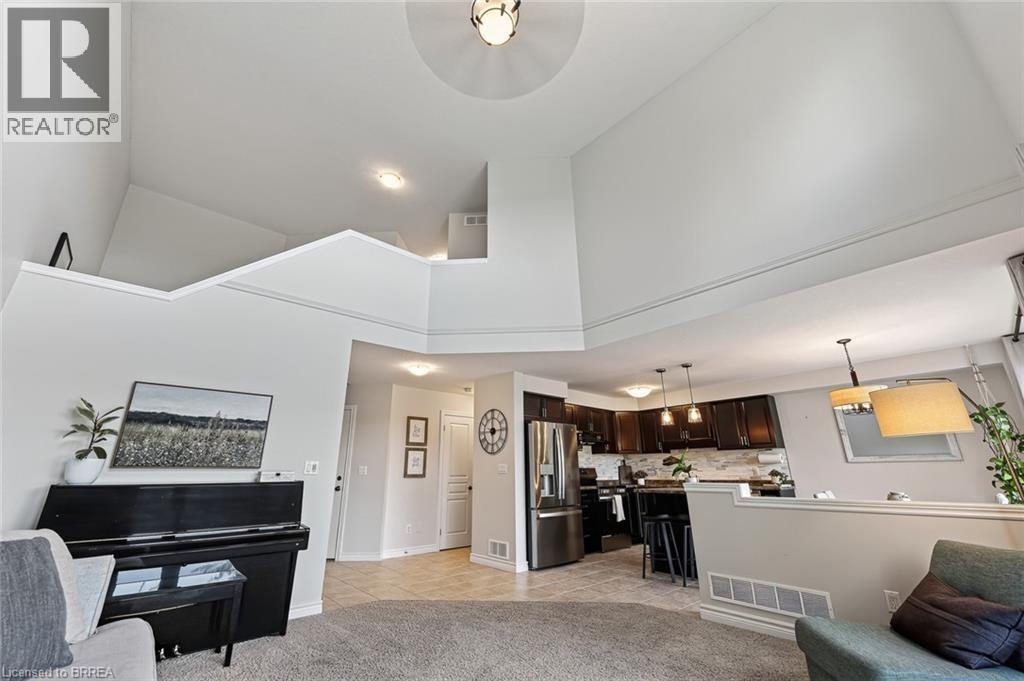 Vaulted ceilings, open concept design, a kitchen with dark wood cabinetry, stainless steel appliances, and a tiled kitchen backsplash - 783 Frontenac Crescent, Woodstock, ON - Indoor
