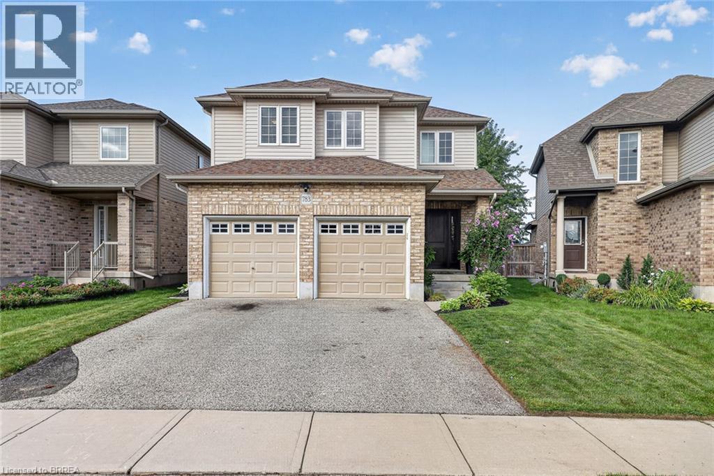 Two-story residence featuring a brick and siding exterior, dual garage doors, and a paved driveway - 783 Frontenac Crescent, Woodstock, ON - Outdoor With Facade