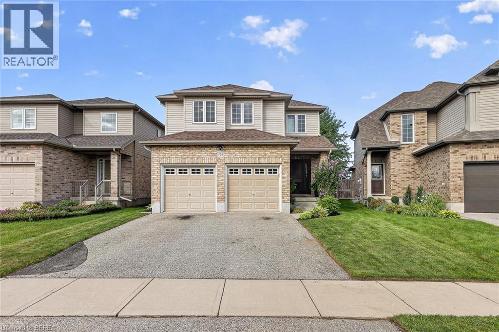 Two-story exterior with brick and siding facade, two-car garage, paved driveway, and manicured front lawn - 783 Frontenac Crescent, Woodstock, ON - Outdoor With Facade