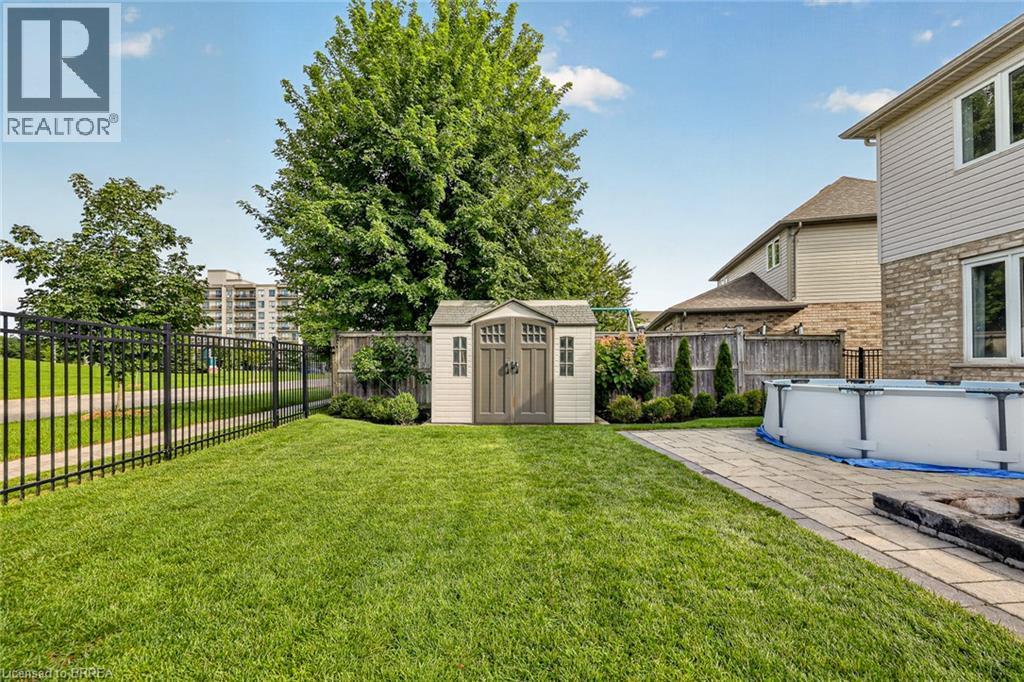 Manicured lawn with a paver patio and an above-ground pool - 783 Frontenac Crescent, Woodstock, ON - Outdoor With Above Ground Pool