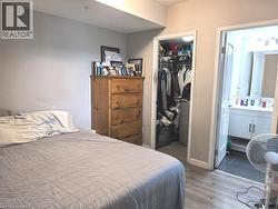 Light gray wall color, wood-finish flooring, recessed lighting, built-in closet, and a full bathroom with a vanity and sink - 