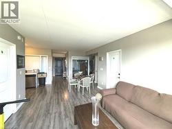 Open-concept living space featuring wood-finish flooring and neutral-toned walls - 