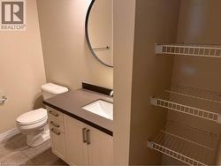 White vanity with dark countertop, integrated sink, and bronze-finish pulls - 