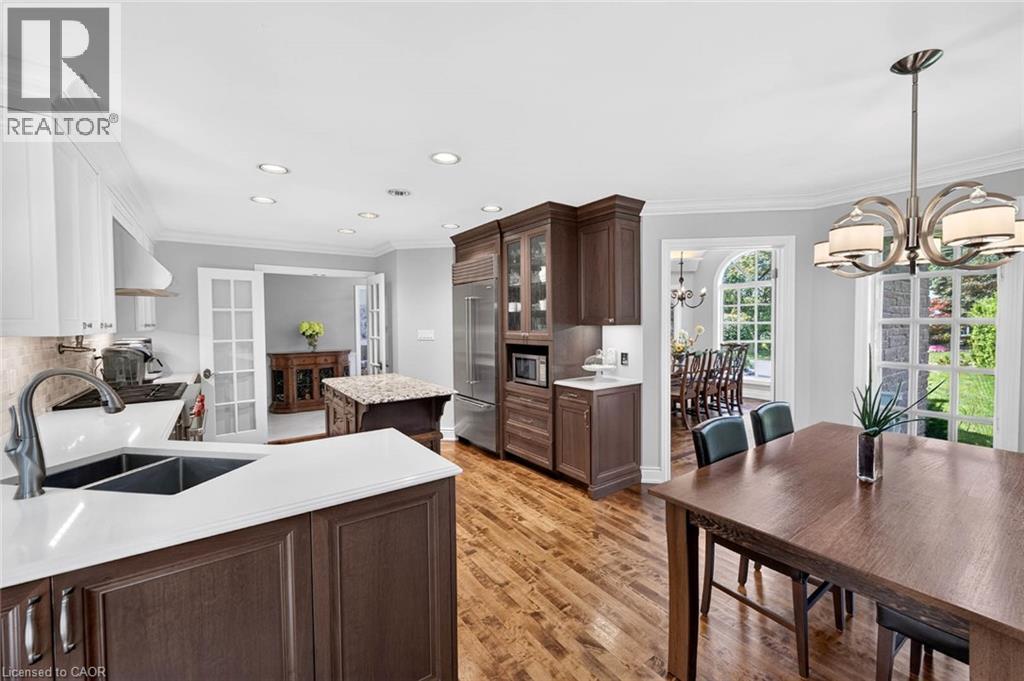 Hardwood flooring, recessed lighting, white perimeter cabinetry, dark wood island with light countertop, and a built-in refrigerator - 11 Christman Court, Markham, ON - Indoor