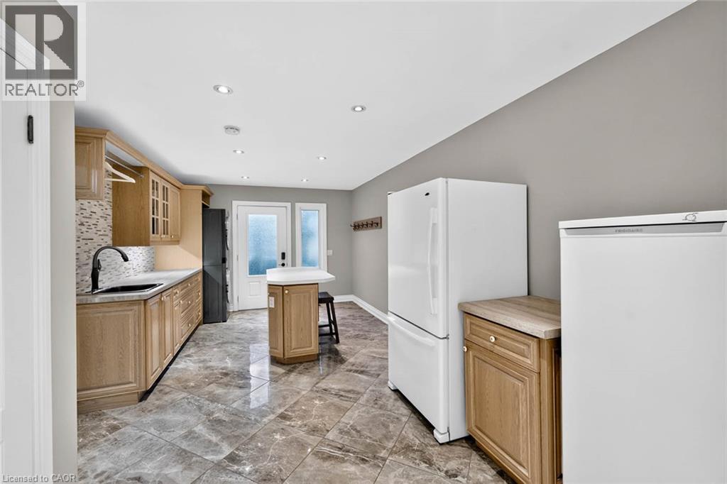 Recessed lighting, wood-finish cabinetry, tile flooring, mosaic tile backsplash, and a black gooseneck faucet - 11 Christman Court, Markham, ON - Indoor Photo Showing Kitchen