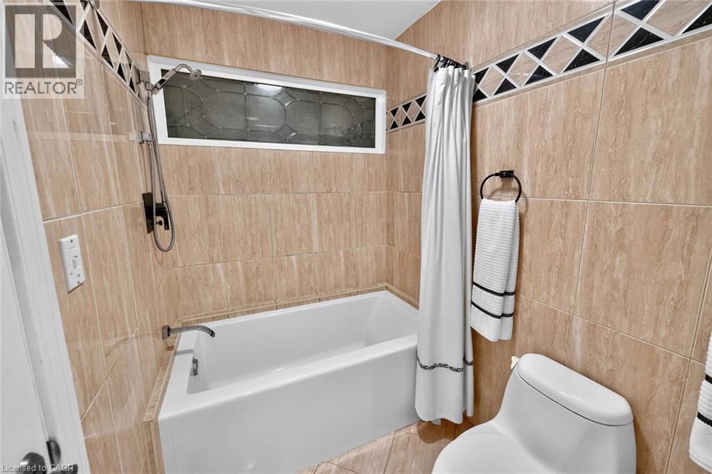 Tiled shower surround with decorative accent band, built-in bathtub, and transom window - 11 Christman Court, Markham, ON - Indoor Photo Showing Bathroom