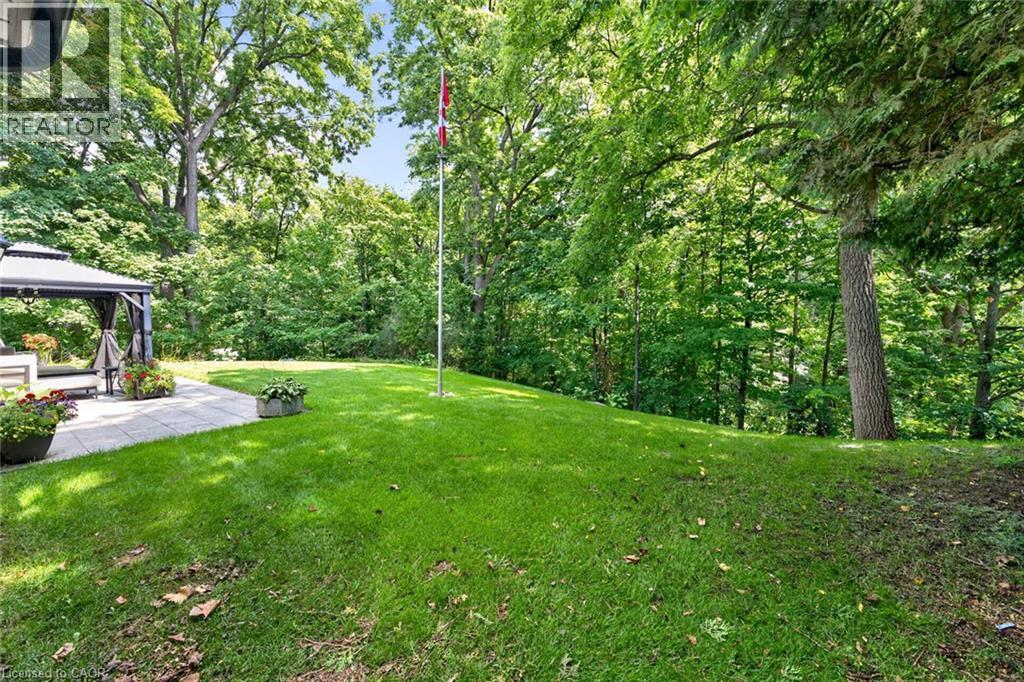 Expansive backyard featuring a manicured lawn, established trees, and a stone paver patio with a built-in gazebo - 11 Christman Court, Markham, ON - Outdoor