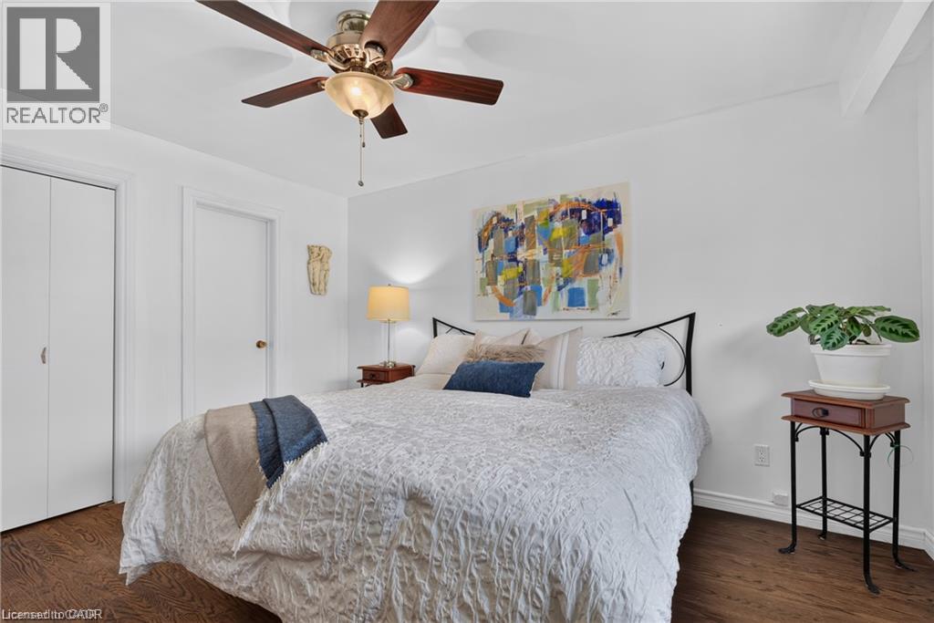 Wood-finish flooring, ceiling fan with integrated lighting, bi-fold closet doors, and solid white walls - 1083 Melton Drive, Mississauga, ON