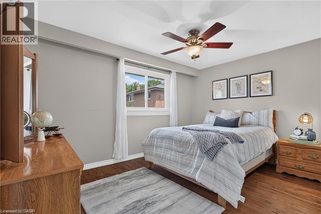 2nd bedroom features wood-finish flooring, neutral wall tones, window with white trim, and a ceiling fan with integrated lighting - 1083 Melton Drive, Mississauga, ON