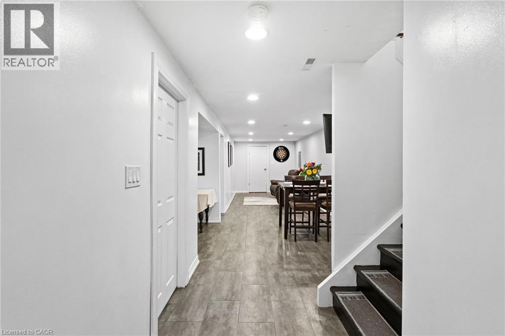 Spacious hallway featuring wood-finish flooring extending through to an open-concept lower-level living area - 1083 Melton Drive, Mississauga, ON