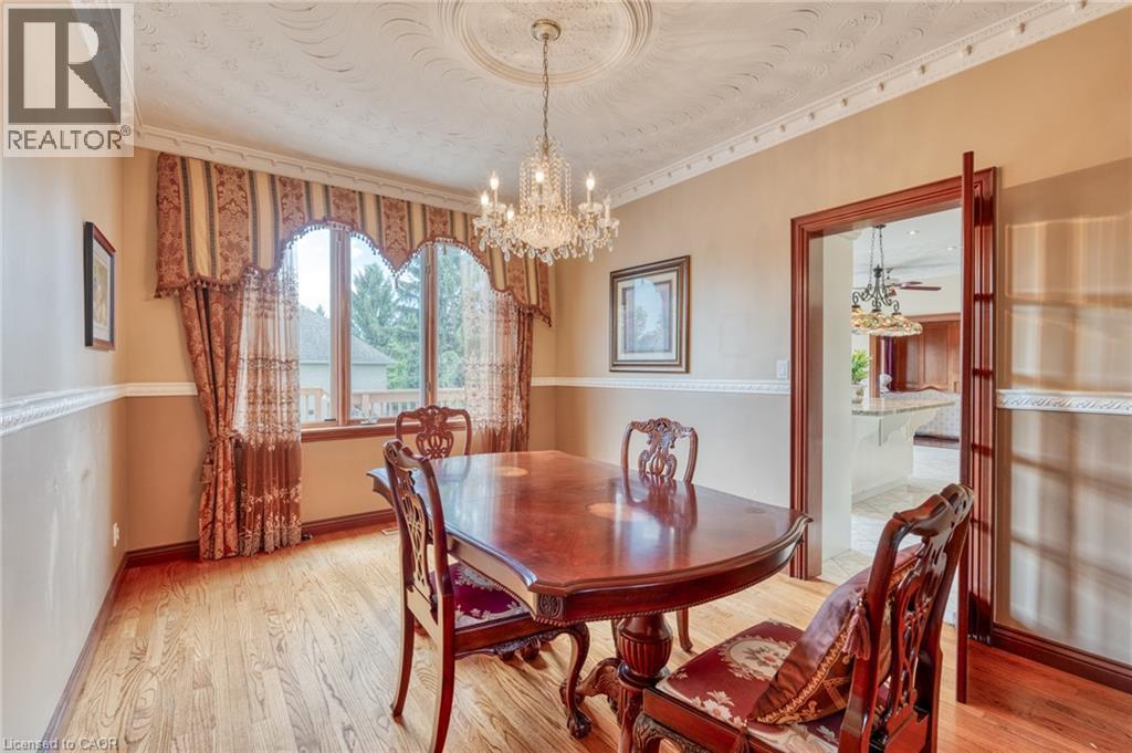 Hardwood flooring, decorative crown molding, wainscoting, chandelier lighting, and a large window - 23 Susan Drive, Hamilton, ON