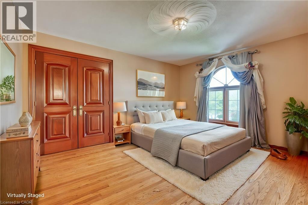 Hardwood flooring, arched window, double panel doors, decorative ceiling medallion, and a flush mount light fixture - 23 Susan Drive, Hamilton, ON