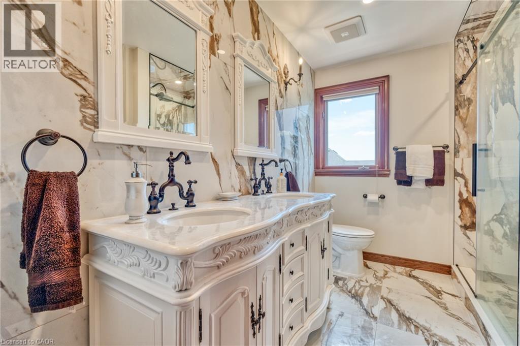 Ornate dual vanity with integrated sinks, framed mirrors, and dark bronze fixtures - 23 Susan Drive, Hamilton, ON