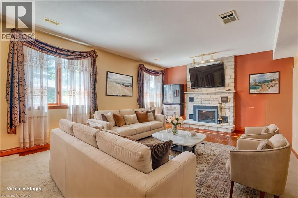 Stone-clad fireplace with mantel, expansive window with custom valance, and recessed lighting - 23 Susan Drive, Hamilton, ON