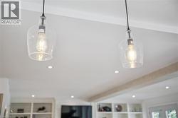 Clear glass pendant lights with exposed filament bulbs, recessed ceiling lighting, and built-in shelving - 