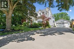 Two-story residence with a prominent chimney, a dormer window, and an attached two-car garage - 