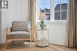 White-framed window with grid pattern, light wood-finish flooring, and crown molding - 