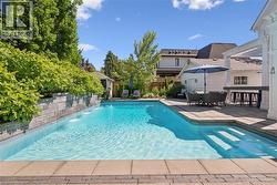 In-ground swimming pool with integrated water features and submerged entry steps - 