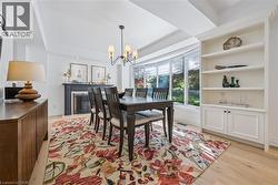 Hardwood flooring, fireplace, bay window, built-in shelving, and a decorative chandelier - 
