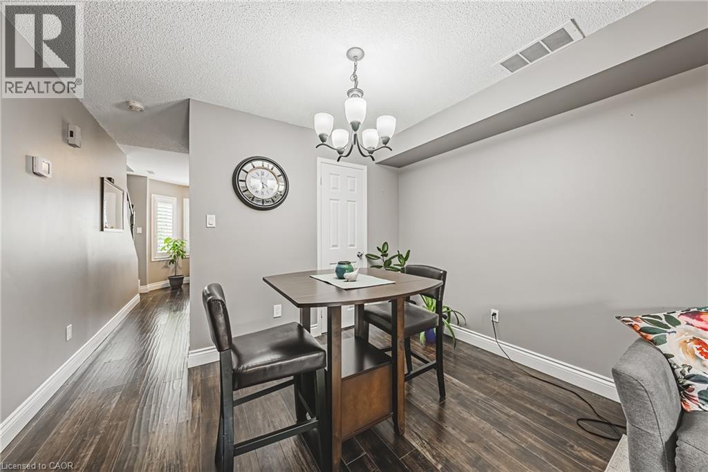 Hardwood-finish flooring throughout, featuring a five-light chandelier and white baseboards - 266 Limeridge Road E Unit# 3, Hamilton, ON