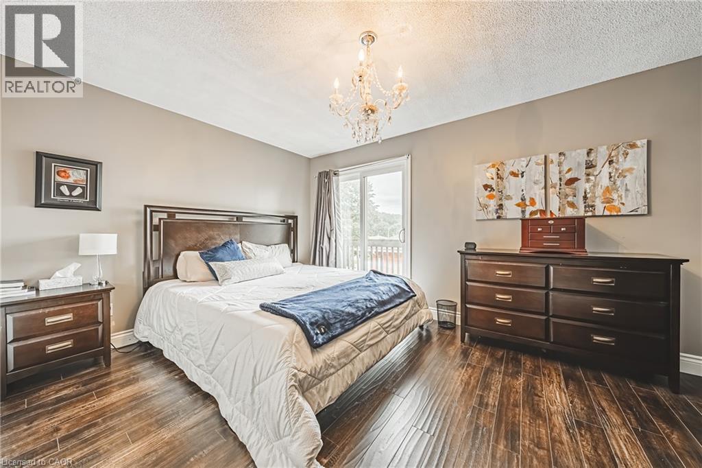 Wood-finish flooring, sliding glass door, overhead chandelier, and neutral wall paint - 266 Limeridge Road E Unit# 3, Hamilton, ON
