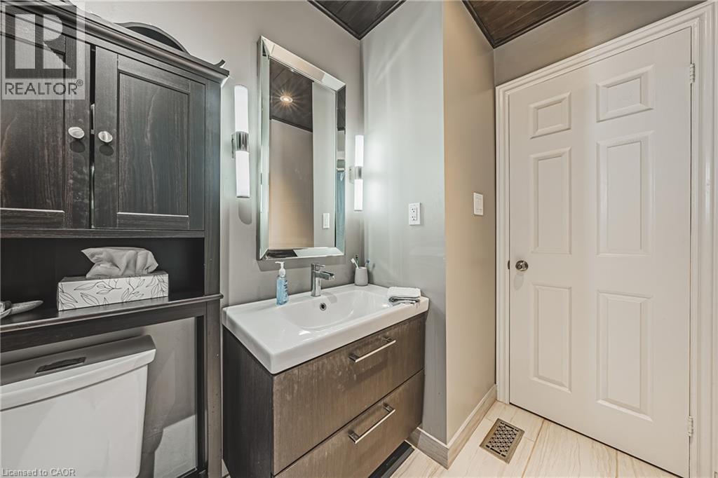 Wall-mounted vanity with integrated sink, rectangular mirror, and sconce lighting - 266 Limeridge Road E Unit# 3, Hamilton, ON