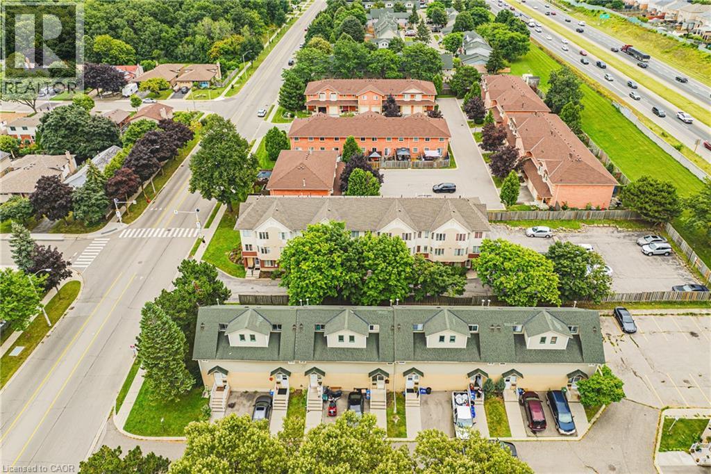 Multi-unit property with dormer windows and individual parking spaces, surrounded by mature trees - 266 Limeridge Road E Unit# 3, Hamilton, ON