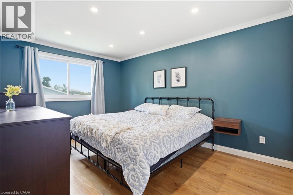 Bright room featuring wood-finish flooring, recessed lighting, and a wide window with white trim - 72 Crestlynn Crescent, Simcoe, ON