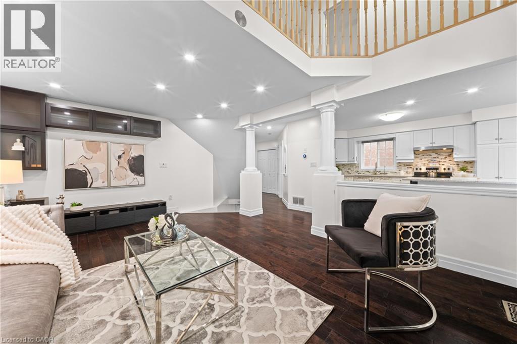 Dark wood-finish flooring complements the white walls and recessed lighting - 495 Brigantine Drive, Waterloo, ON