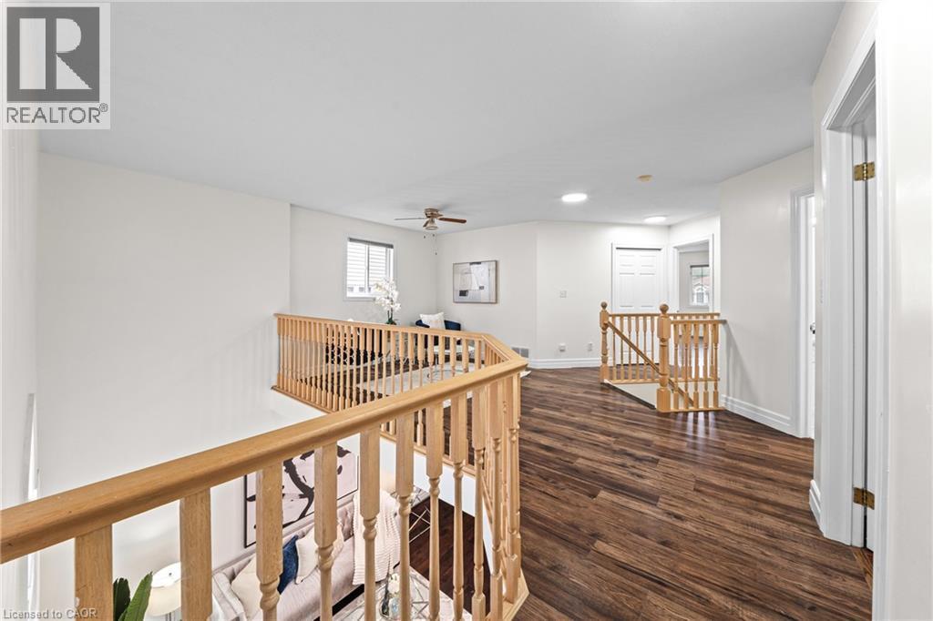 Open-concept upper level featuring wood-finish flooring, recessed lighting, and natural wood railings - 495 Brigantine Drive, Waterloo, ON