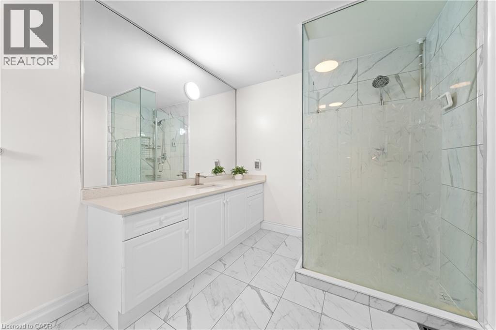 White vanity with dual integrated sinks, brushed nickel faucets, and a light-toned countertop - 495 Brigantine Drive, Waterloo, ON