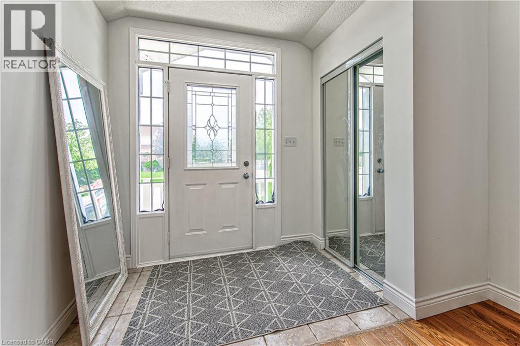 Entryway with a paneled door featuring decorative glass, sidelight windows, and a transom window - 168 Copper Leaf Street, Kitchener, ON