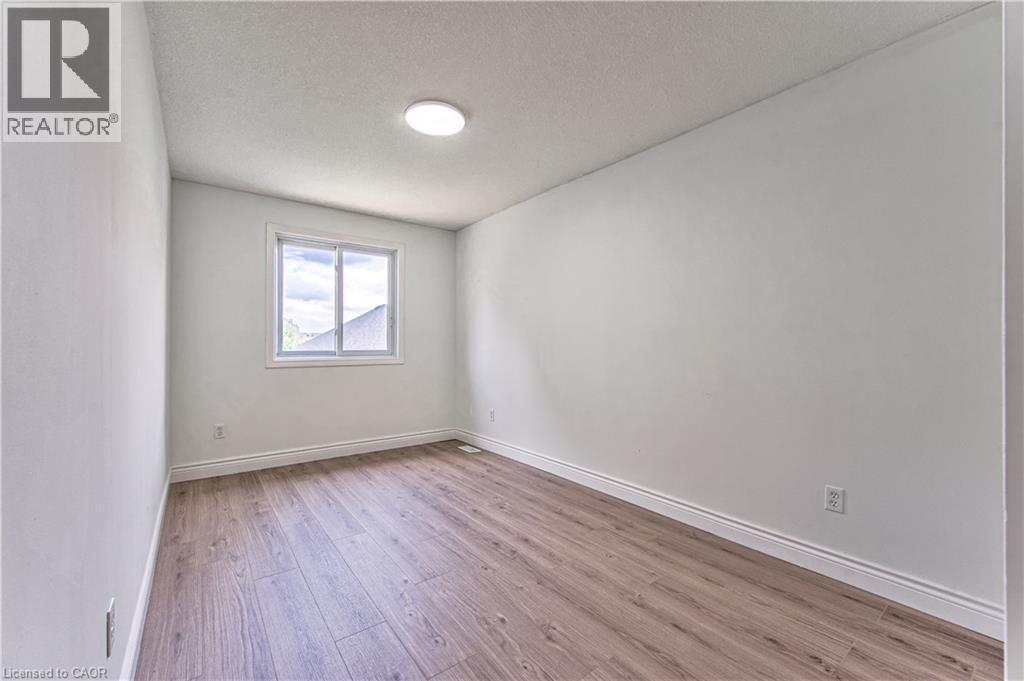 Recessed ceiling lighting, wood-finish flooring, and a single window with white trim - 168 Copper Leaf Street, Kitchener, ON