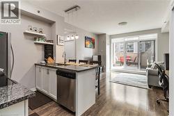 Kitchen with granite-style countertops, stainless steel appliances, and white cabinetry - 