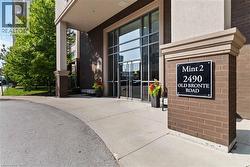 Modern architectural entrance featuring a seamless glass and aluminum storefront system, polished concrete flooring, and contemporary brick and stone exterior cladding - 