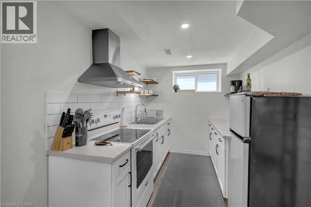 Compact kitchen featuring white cabinetry, light countertops, and a white subway tile backsplash - 450 Highland Road E, Kitchener, ON